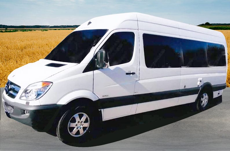 White Mercedes Sprinter van conversion on the road.