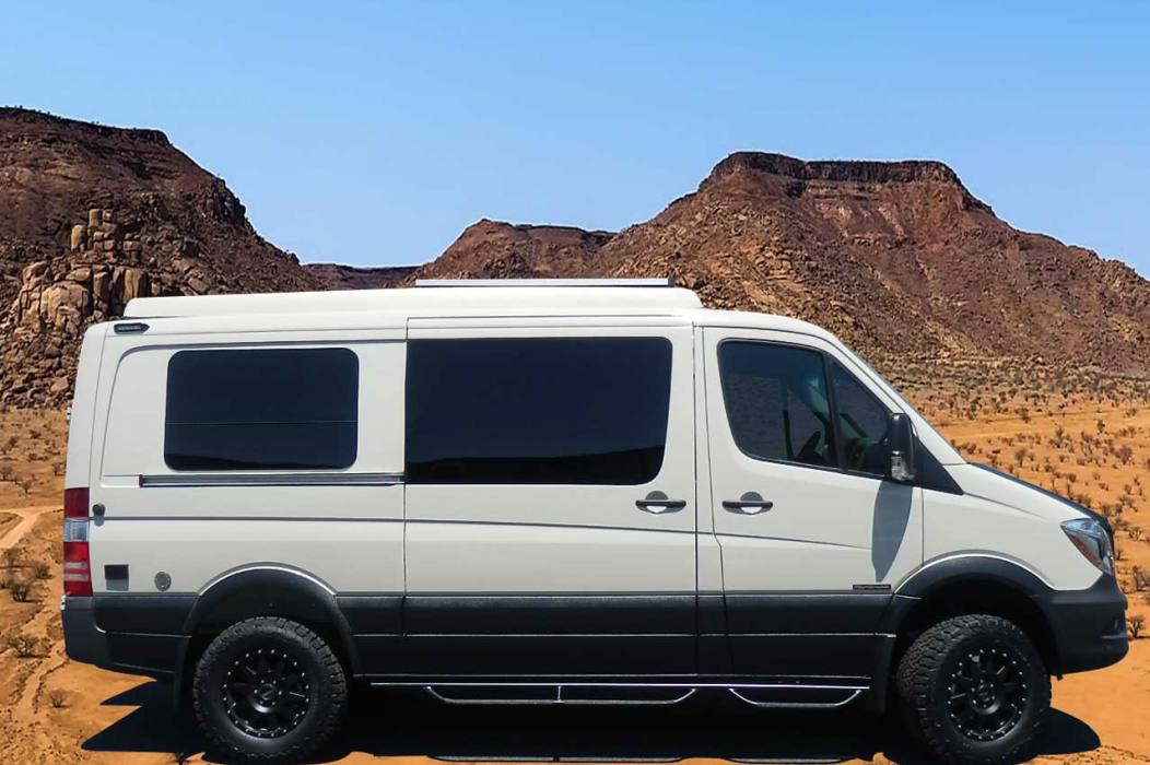 Profile view of a white and black Transit camper conversion van.