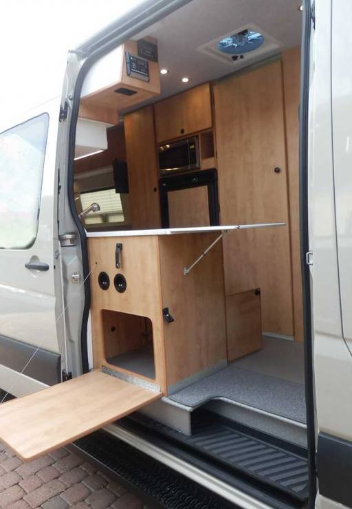 Ford Transit camper conversion featuring a galley with inside and outside access