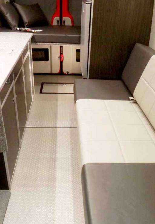 Interior view of a custom Sportsmobile Sprinter 4x4 van conversion with gaucho seats with seat belts and cushions.