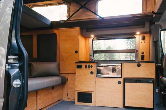 Custom wood cabinets and trim in this Sprinter van conversion.