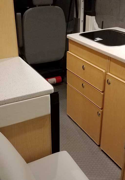 Interior view of refrigerator inside the galley of this van conversion.