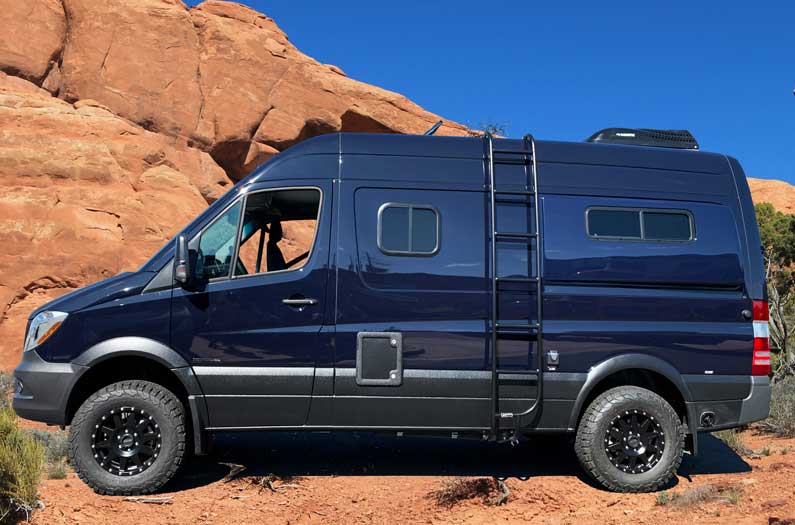 Dark blue Mercedes-Benz Sprinter conversion van with side ladder.